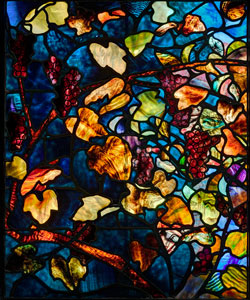 A stained glass window composed of autumn leaves.